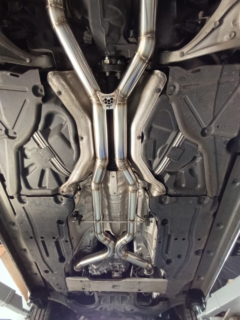 Custom twin stainless exhaust system installed beneath a customer vehicle